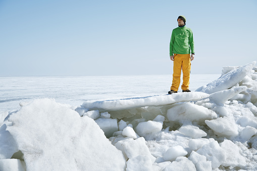 Young adult man outdoors exploring icy landscape