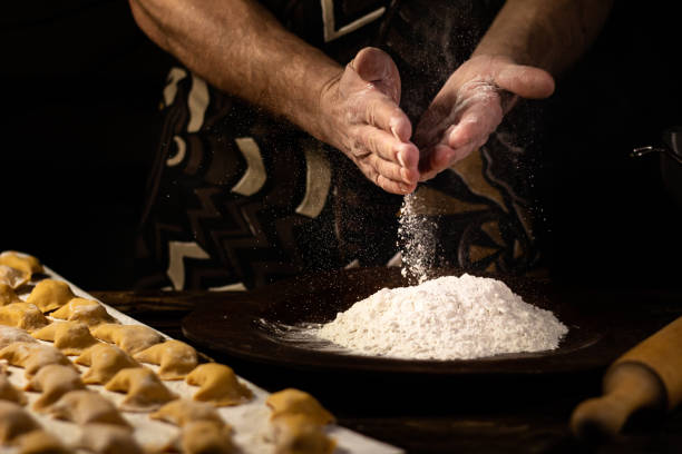istock Strong men's hands sprinkle flour dumplings. Ukrainian national dish. 1301915189