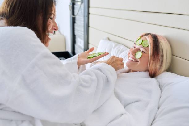 Mom and teenage daughter taking care of face using natural cosmetics and cucumber Relaxation together, beauty treatments. Mom and teenage daughter are taking care of face using natural cosmetics and cucumber masks. Beauty, clean spa skin care, parent teen child communication women facial mask mud cucumber stock pictures, royalty-free photos & images