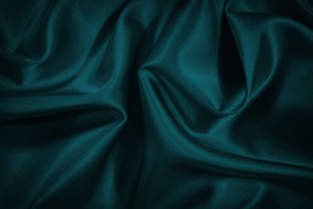 istock Black blue green abstract background. Dark green silk satin texture background. Beautiful wavy soft folds on the surface of the fabric. 1301916397