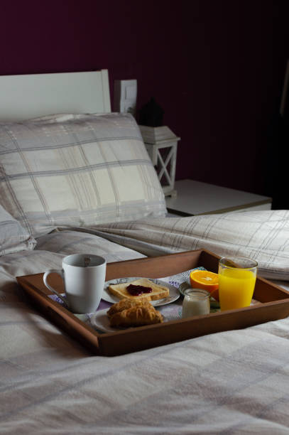 istock vertical image of a tray with a very complete breakfast on the bed. Romantic breakfast concept 1301917060