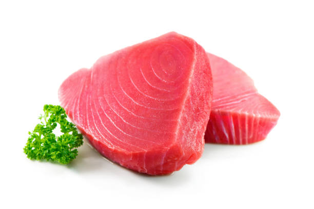 bistecche di filetto di tonno fresco guarnite con prezzemolo isolato su sfondo bianco - prepared tuna foto e immagini stock