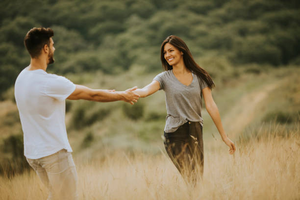 istock Happy young couple in love walking through grass field 1301918355