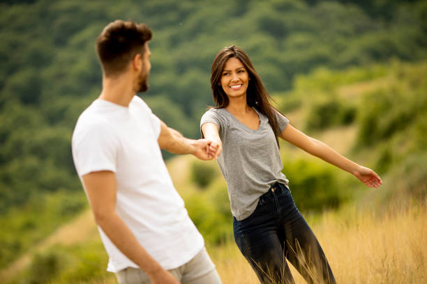 istock Happy young couple in love walking through grass field 1301918364