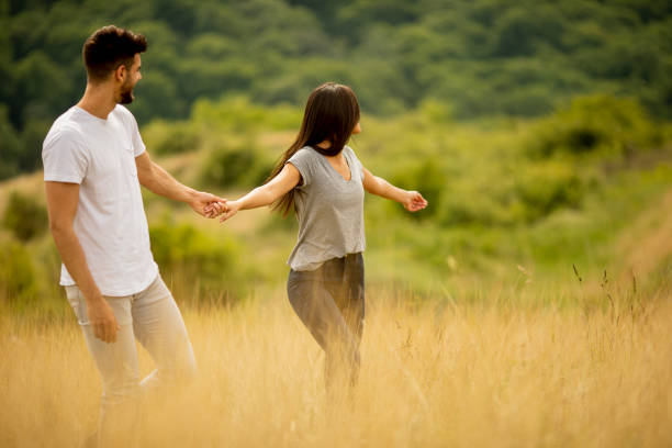 istock Happy young couple in love walking through grass field 1301918370
