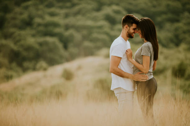 istock Happy young couple in love walking through grass field 1301918384