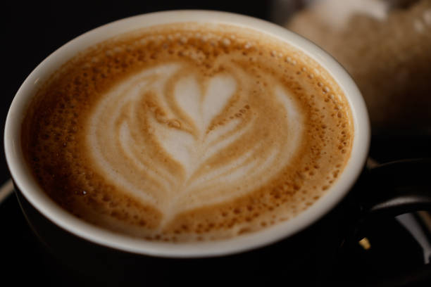 istock Flat white on a coffee cup with a heart-shaped flower drawn with milk foam. For use as background, selective focus 1301919973