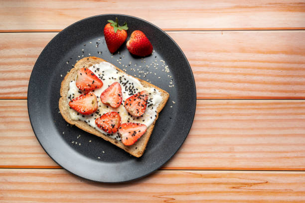 istock Healthy breakfast toasts with strawberry, Yoghurt with whole grain sandwich bread on black dish. Concept of healthy eating, dieting, vegan vegetarian food 1301920719