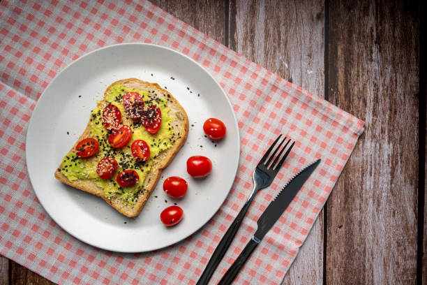 Healthy breakfast toasts with Avocado toast, tomato with whole grain sandwich bread on white dish. Concept of healthy eating, dieting, vegan vegetarian food