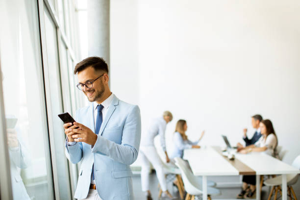 istock Young businessman with a mobile phone in the office 1301924275