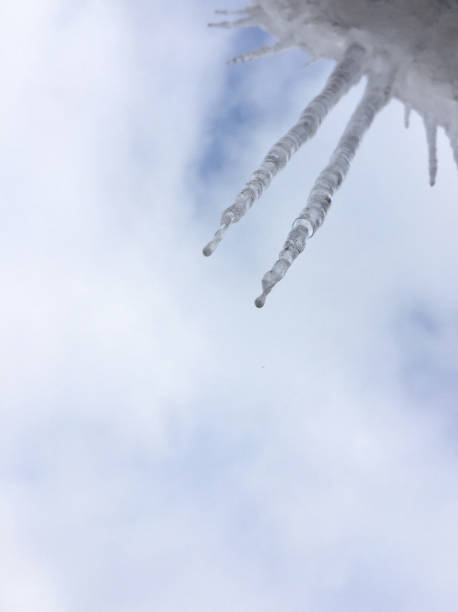 carámbanos colgando del techo contra el cielo, vista de abajo hacia arriba - clear sky diagonal snow winter fotografías e imágenes de stock