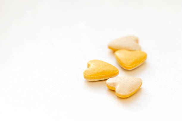 istock Heart shaped yellow vitamin pills on white background 1301925467