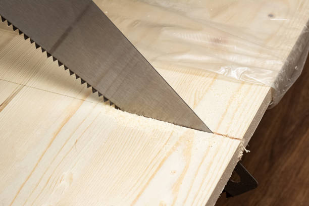 istock Sawing a wood board with a saw 1301925476