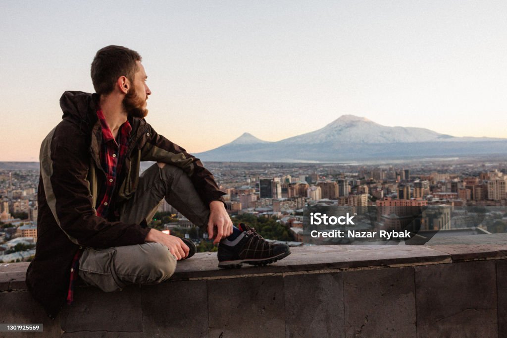 Young man at the Yerevan city and Mount Ararat background at the sunset in Armenia Armenia - Country Stock Photo
