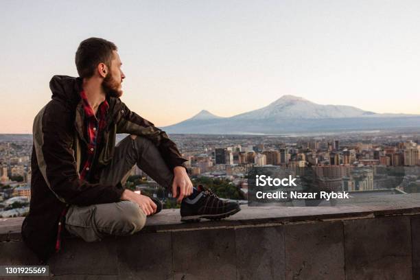 Young Man At The Yerevan City And Mount Ararat Background At The Sunset In Armenia Stock Photo - Download Image Now