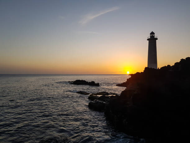 istock Lighthouse at sunset in the sea 1301925570