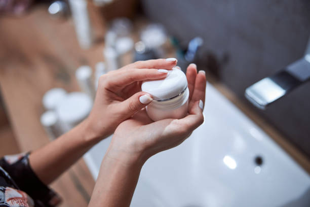 istock Woman shutting the cream box with a cap 1301928580