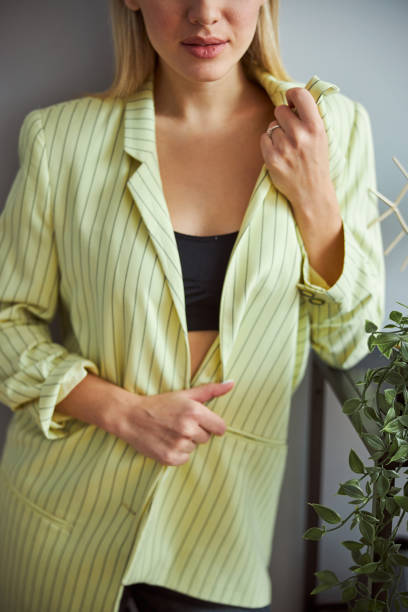 istock Female undoing the button on her shirt 1301928597
