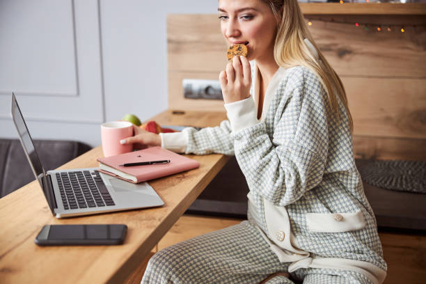 istock Woman biting a chocolate cookie while holding teacup 1301928662