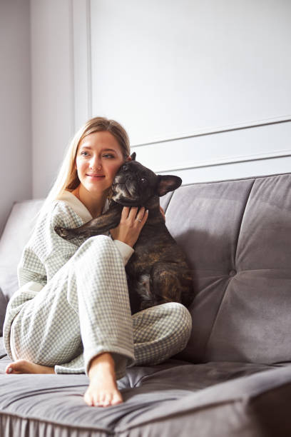 istock Woman embracing black dog on a bed 1301928694