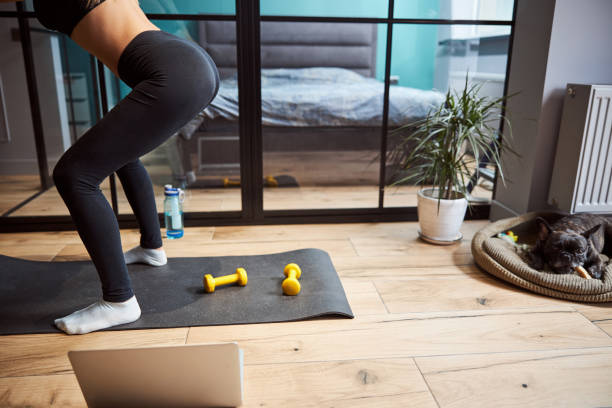 istock Sportsperson doing squats on a rug at home 1301928744