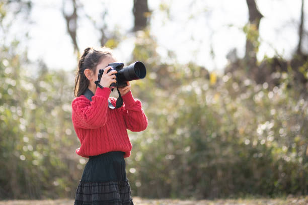 istock A girl taking a picture with a single-lens reflex camera 1301933421