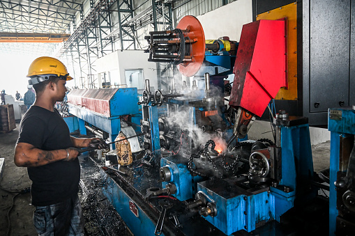 Iron tube welding in a factory in India. High efficiency switch welder operating in Raipur, India.