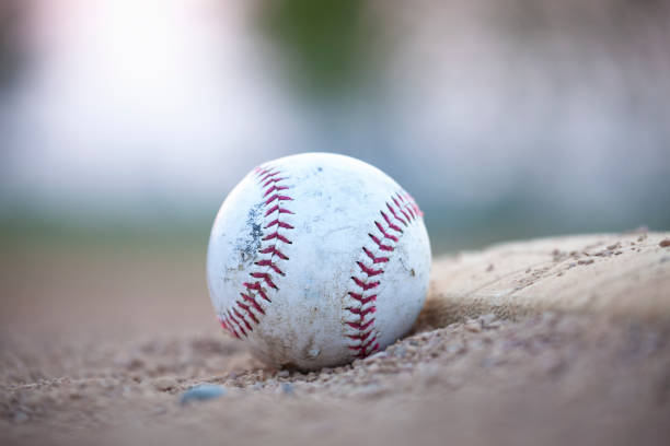 istock Selective focus low angle view of an old baseball next to a base 1301936727