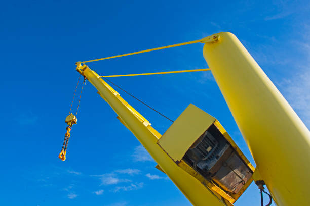 istock Large crane jib against blue sky background 1301937351