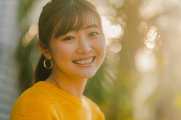 Portrait of beautiful woman in yellow sweater in nature A portrait of a beautiful woman in a yellow sweater in nature on a sunny day. japanese woman stock pictures, royalty-free photos & images