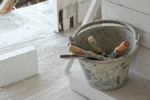 istock construction tool in old can at house site. prepare equipment for install wall white brick. put on cement floor 1301938559