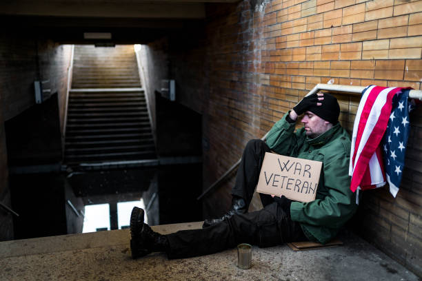 homeless holding cardboard sign with text "war veteran" - depression sadness usa american flag imagens e fotografias de stock