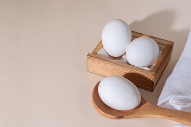 oeufs de poulet dans une boîte en bois sur le fond beige avec l’espace de copie, produit avec des acides aminés choline lecithin cholestérol calcium potassium phosphore vitamines protéine iode alimentation saine - lecithin photos et images de collection