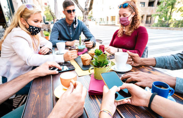 istock Bored people using mobile smart phones at coffee bar - New normal gathering concept with worried people sharing content online on social media network - Bright filter with focus on lower right hand 1301942526