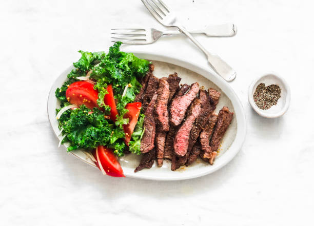 istock Beef steak and kale, tomato salad - delicious balanced diet lunch on a light background, top view 1301944802