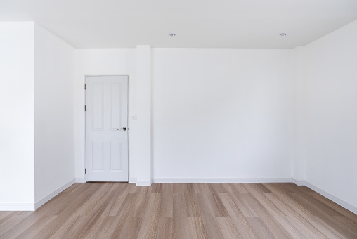 Home interior, empty room. White wall and ceiling with wood floor