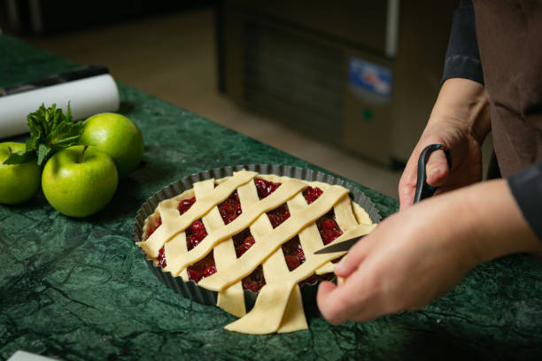 istock Female baker prepares cherry pie 1301947425