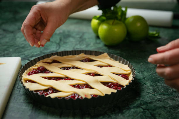 istock Female baker prepares cherry pie 1301947439