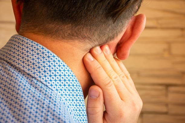 Pain behind ear in area of mastoid process concept photo. Person holds his hand over area behind ear, where pain is suspected due to otitis media, inflammation, noise in ear, hearing loss Pain behind ear in area of mastoid process concept photo. Person holds his hand over area behind ear, where pain is suspected due to otitis media, inflammation, noise in ear, hearing loss neuralgia stock pictures, royalty-free photos & images