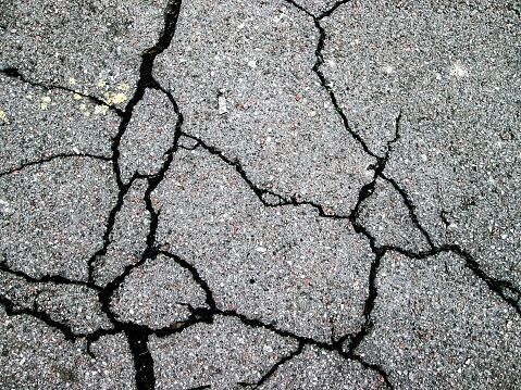 Crack in the asphalt. Lines of destruction of the stone road.