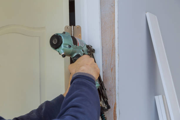 istock Construction of the wooden frame installation interior room doors in worker using nail gun 1301953492