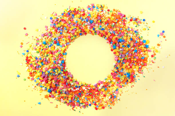 istock Sweet candy confetti in the middle of a circle with empty space for text. Yellow background 1301953561