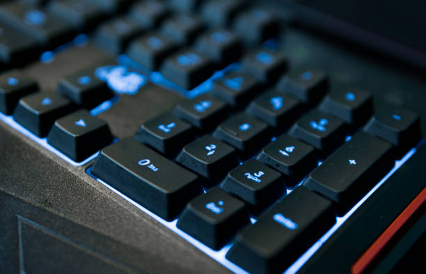 Gamer keyboard with colorful blue lights, modern gamer computer. Blue backlight, backlit on laptop or keyborad computer of gaming. Gamer keyboard with colorful blue lights, modern gamer computer. Blue backlight, backlit on laptop or keyborad computer of gaming keyborad stock pictures, royalty-free photos & images