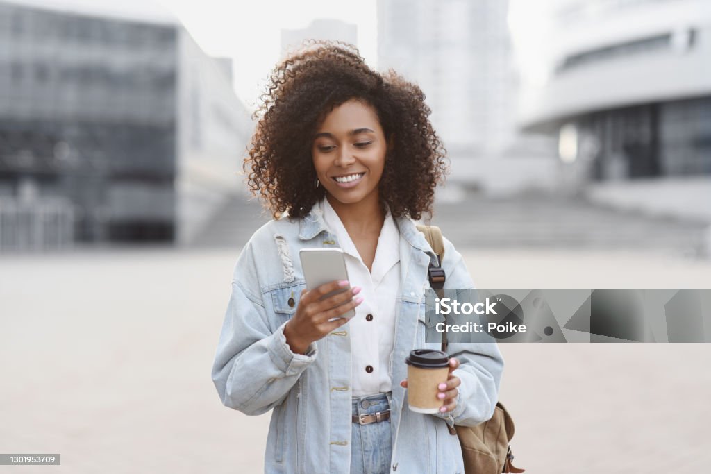 街の通りでスマートフォンを使う若い女性 - 電話を使うのロイヤリティフリーストックフォト
