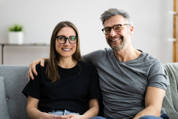 Happy Couple Family On Sofa Happy Couple Family On Sofa Or Couch Wearing Eye Glasses pair stock pictures, royalty-free photos & images