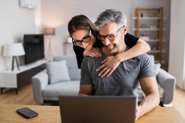 istock Happy Couple Looking At Laptop 1301956669