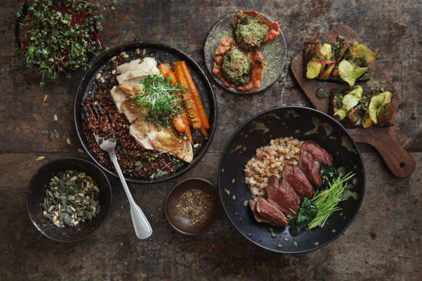 Traditional Danish Dishes Sous vide chicken breast with carrot and quinoa. Grilled venison steak with spelt grain and microgreen. Traditional Danish smorrebrod with salted saffron mushrooms, potato and homemade mayonnaise. Venison tartar with beetroot tapioca cracker and herb. Flat lay top-down composition on dark background. danish culture stock pictures, royalty-free photos & images