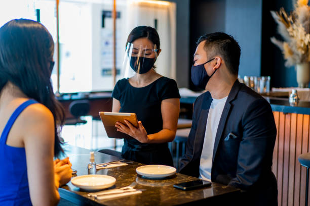 istock Asian waitress with protective face mask and face shield taking food orders. 1301957900