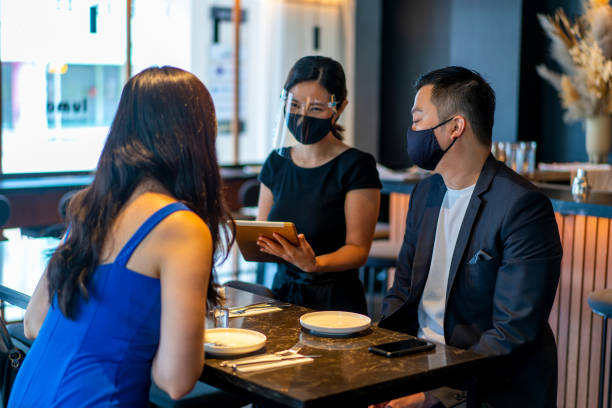 istock Asian waitress with protective face mask and face shield taking food orders. 1301958005