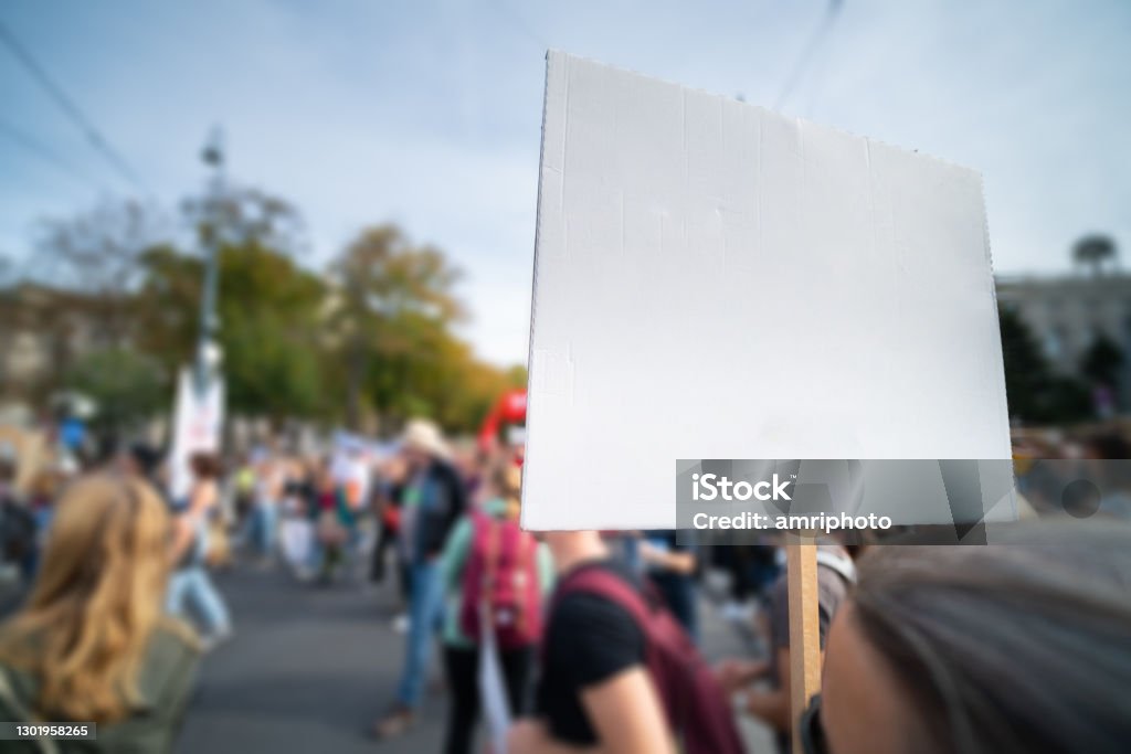 people protesting on street, empty sign with place for your text sign showing protest against something at a demo march demonstration place for text Fridays for Future Stock Photo